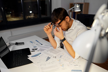Image showing tired businessman working at night office