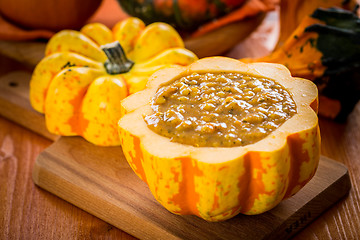 Image showing Red lentils soup with pumpkins served in hollowed pumpkin