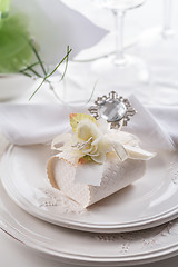 Image showing Festive table setting with small gift on plate