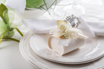 Image showing Festive table setting with small gift on plate