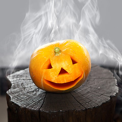 Image showing Pumpkin that laughs on a charred stub in smoke