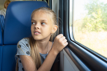 Image showing Girl sitting by the window in an electric train car