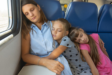 Image showing Mom and two daughters fell asleep in an electric train car