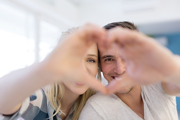 Image showing couple making heart with hands