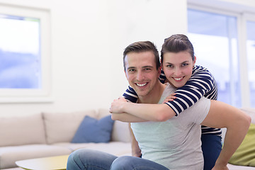 Image showing handsome man piggybacking his girlfriend