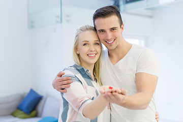 Image showing couple showing small red house in hands