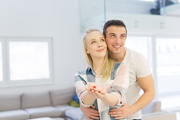 Image showing couple showing small red house in hands