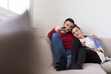 Image showing Young couple on the sofa watching television