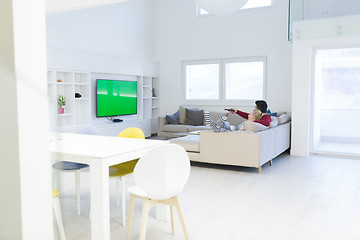 Image showing Young couple on the sofa watching television