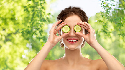 Image showing smiling woman with cucumber over grey background