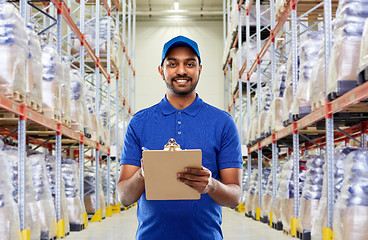 Image showing indian delivery man with clipboard at warehouse