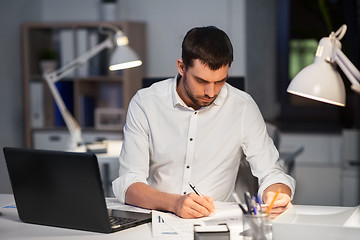 Image showing businessman with papers working at night office