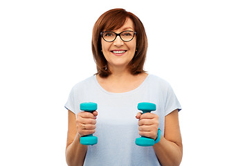Image showing smiling senior woman with dumbbells exercising
