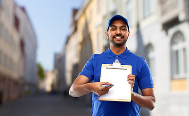 Image showing happy indian delivery man with clipboard in city