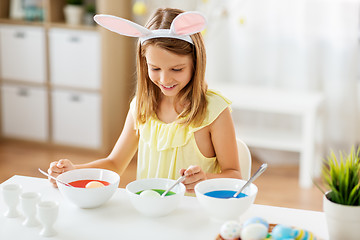 Image showing girl coloring easter eggs by liquid dye at home