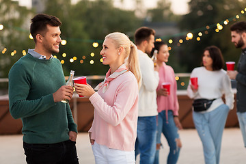 Image showing friends with drinks in party cups at rooftop