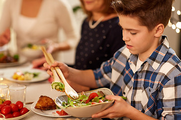 Image showing close up of boy with salad at family dinner party