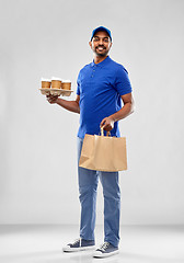 Image showing happy indian delivery man with food and drinks