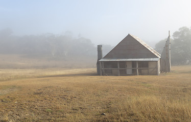 Image showing Log hut in Snowy Mountains with early morning fog