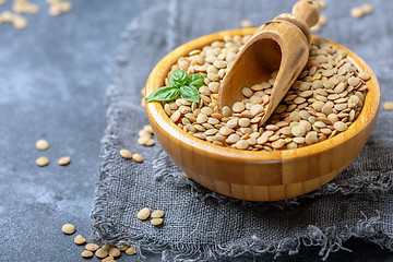 Image showing Organic brown lentils and wooden scoop in a bowl.