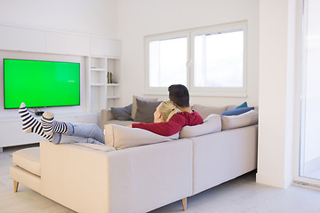 Image showing Young couple on the sofa watching television