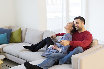 Image showing Young couple on the sofa watching television