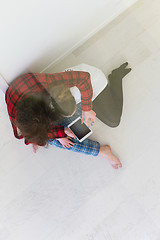 Image showing Young Couple using digital tablet on the floor