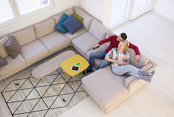 Image showing Young couple on the sofa watching television