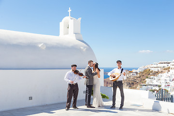 Image showing Bride and groom dansing on wedding ceremony on Santorini island, Greece.