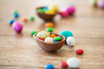 Image showing chocolate easter egg and candy drops on table