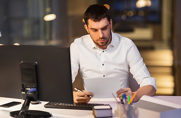 Image showing businessman with papers working at night office