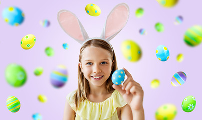 Image showing happy girl with colored easter egg over violet