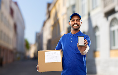 Image showing delivery man with smartphone and parcel in city