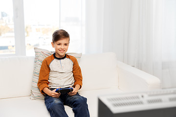 Image showing happy boy with gamepad playing video game at home