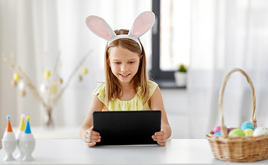 Image showing happy girl with tablet pc and easter eggs at home