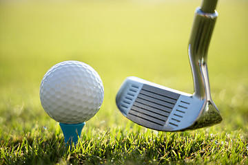 Image showing Golf ball on tee in front of driver