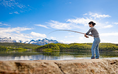 Image showing Woman fishing on Fishing rod spinning in Norway.