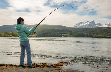 Image showing Woman fishing on Fishing rod spinning in Norway.