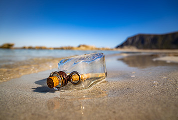 Image showing Message in the bottle against the Sun setting down