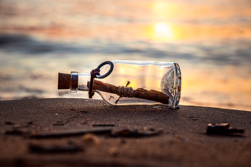 Image showing Message in the bottle against the Sun setting down