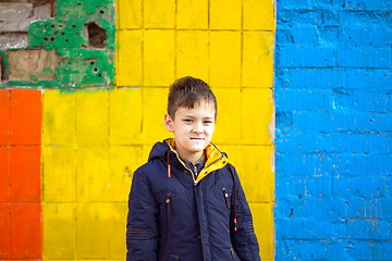 Image showing Funny boy against color brick wall