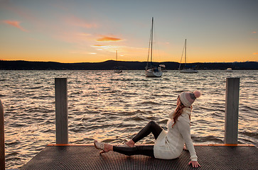 Image showing Woman watching a cool winter sunset from the jetty