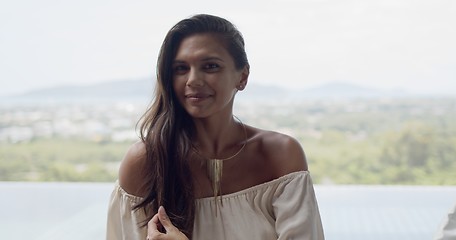 Image showing Pleased woman looking at camera while resting on terrace