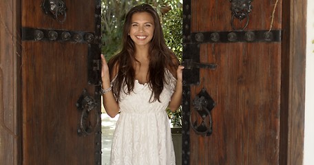 Image showing Cheerful woman opening old wooden doors