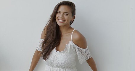 Image showing Happy young woman in white dress looking at camera