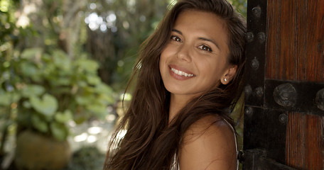 Image showing Relaxed woman leaning on wooden door