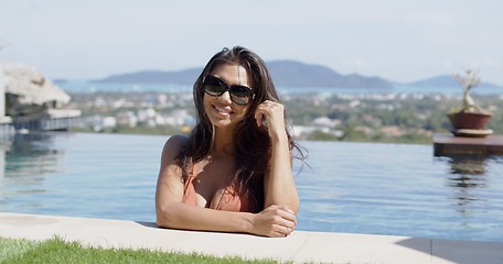 Image showing Pretty woman refreshing in pool in hot day