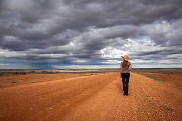 Image showing Farm girl watching storm over the arid desert