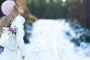 Image showing Woman on a snow covered road in the forest