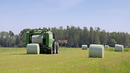 Image showing Baler Wrapper Baling Silage in Field